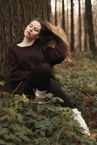Portrait of woman with closed eyes sitting in the forest 