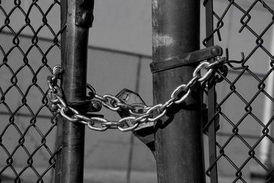 Close-up of padlock on chainlink fence