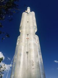 Low angle view of trees against blue sky
