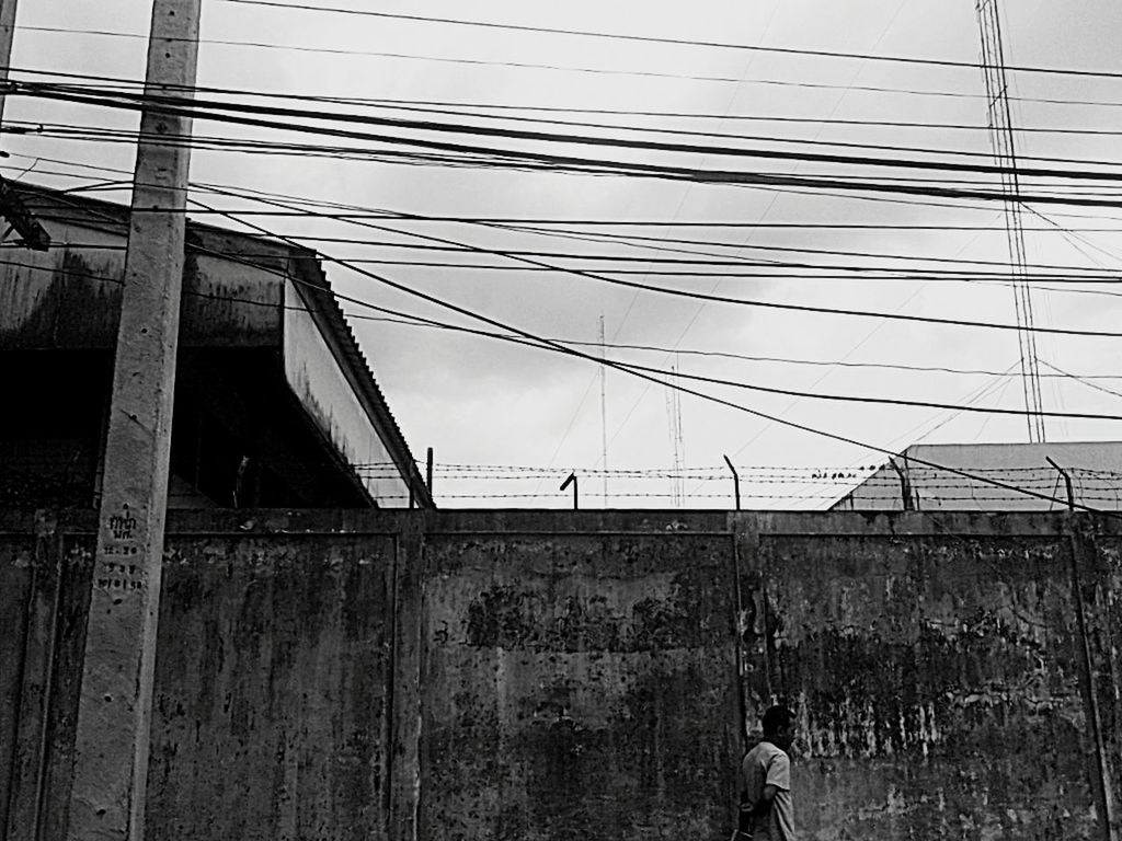 architecture, built structure, building exterior, power line, low angle view, electricity pylon, cable, sky, power supply, house, fuel and power generation, building, day, electricity, residential structure, no people, outdoors, fence, connection, abandoned