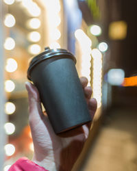 Close-up of hand holding illuminated electric lamp