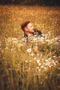 Young man looking away in field