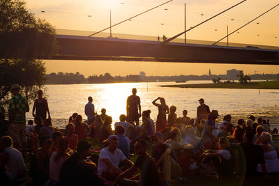 People on bridge over river in city