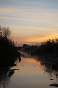 Scenic view of lake against orange sky