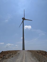 Low angle view of windmill on field against sky