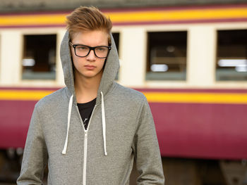 Portrait of young man standing by train