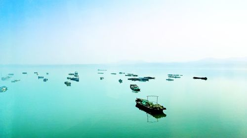 Boats moored on sea against sky