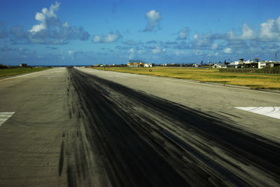 Road passing through land against sky