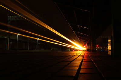 Light trails on railroad station platform at night