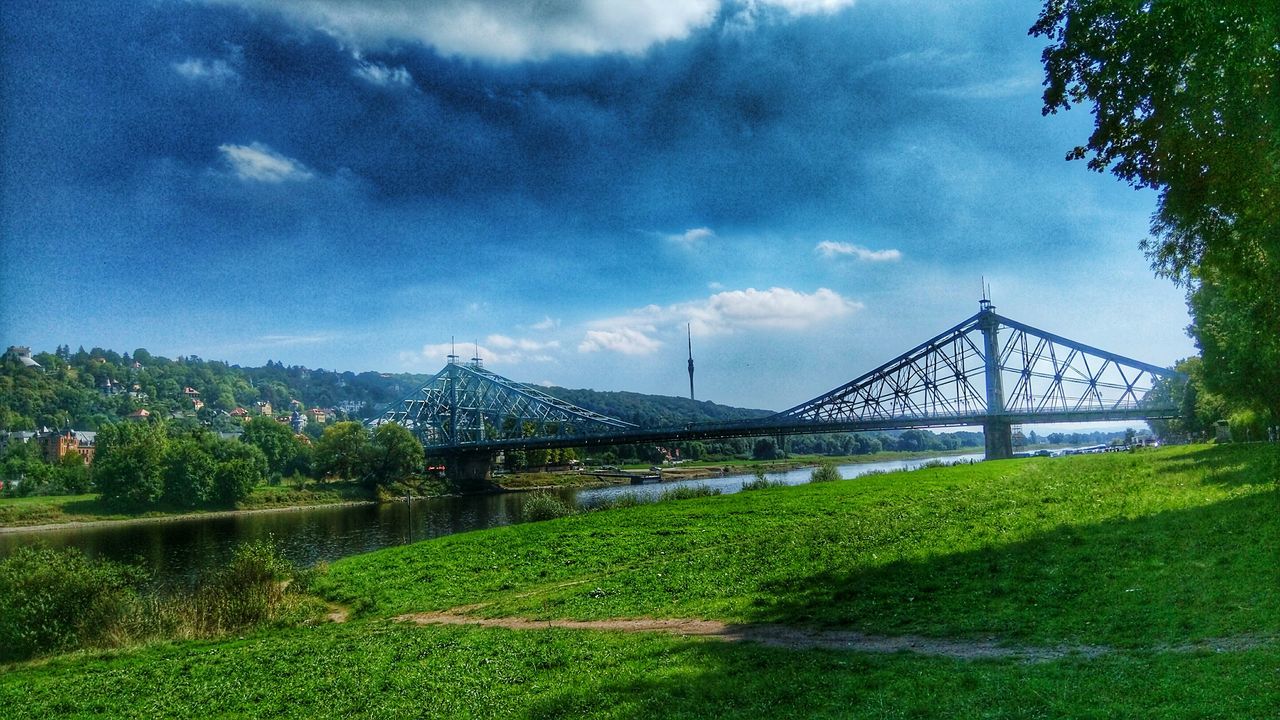 sky, architecture, built structure, tree, cloud - sky, grass, connection, green color, bridge - man made structure, cloud, growth, plant, cloudy, nature, railing, park - man made space, flower, day, tranquility, no people