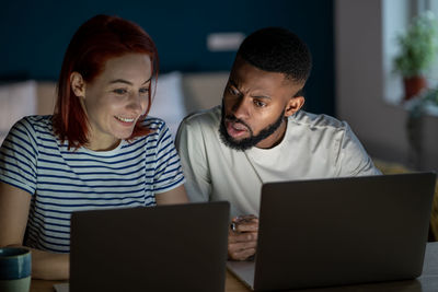 Friends using laptop at home