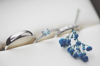 Close-up of wedding rings with artificial flower in box