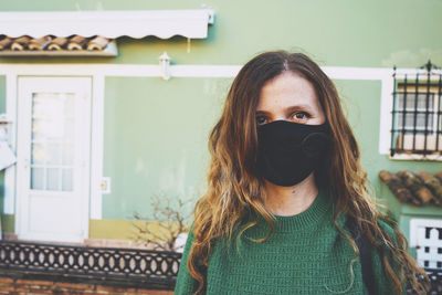 Portrait of woman standing against built structure