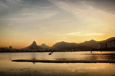 Idyllic view of lake against sky during sunset in city