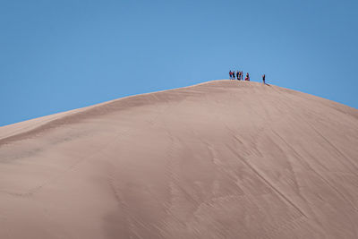 Scenic view of desert against clear blue sky