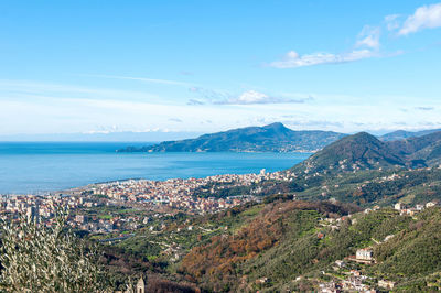 Aerial view of city by sea against sky