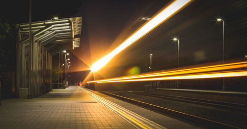 Light trails on railroad station platform at night