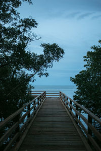 View of wooden bridge against sky