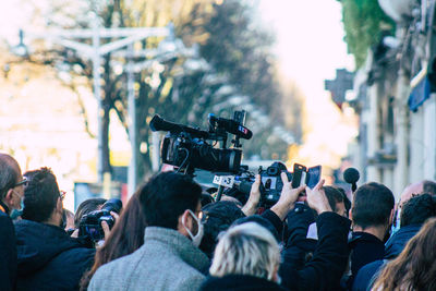 Rear view of people photographing at music concert