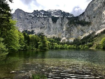 Scenic view of lake by mountains against sky