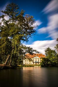 Building by river against sky