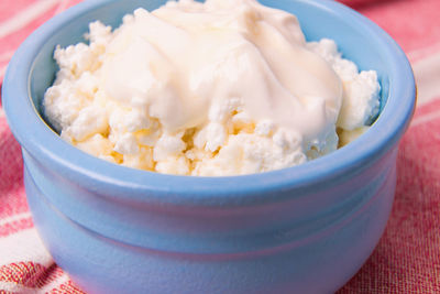 Cottage cheese in a blue bowl with sour cream and honey.