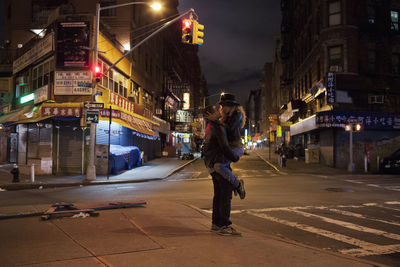 Full length of man walking on illuminated street at night