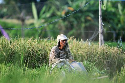 Man sitting on grass in field