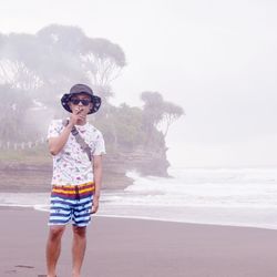 Full length portrait of man standing against sky