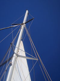 Low angle view of sailboat against clear blue sky