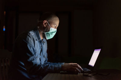 Young man using laptop while sitting on table