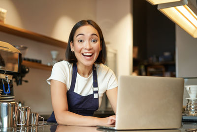 Portrait of young woman using laptop at table