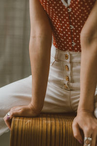 Hands of girl in white jeans and red dotted corse