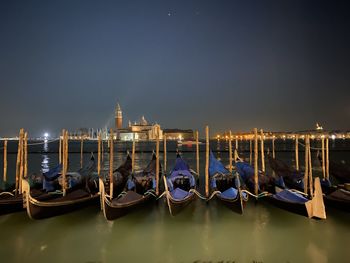 Boats moored in venice canal at night