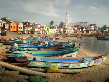 Boats moored in city against sky