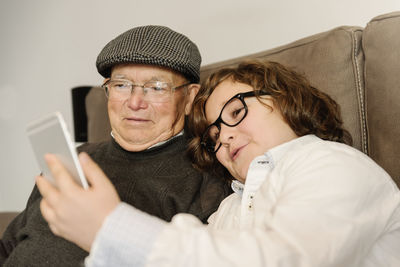 Teenage boy taking selfie with grandfather