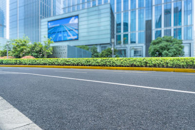 Empty road by buildings in city