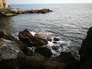 Rock formation in sea against sky