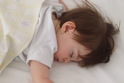 High angle view of baby girl sleeping on bed at home