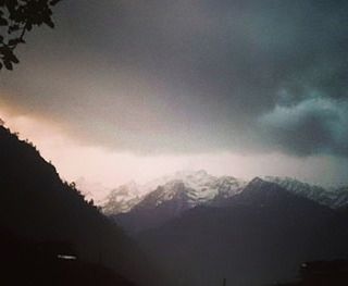 Scenic view of mountains against cloudy sky