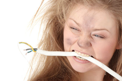 Close-up portrait of woman holding hands over white background
