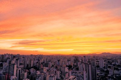 Aerial view of buildings against sky during sunset