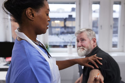 Female doctor vaccinating senior patient