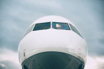 Close-up of airplane on runway against sky