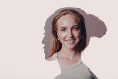 Portrait of smiling young woman against white background