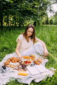 Portrait of smiling young woman sitting on field