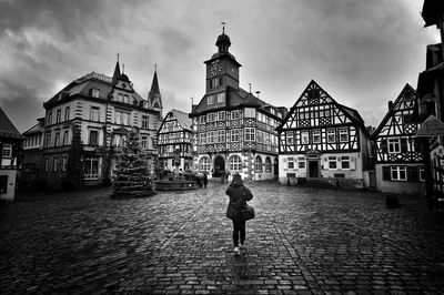 Rear view of man walking in front of historic building