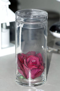 Close-up of pink glass jar on table