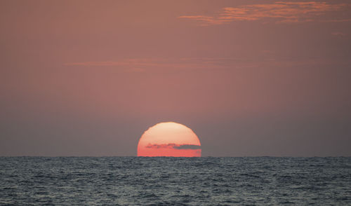 Scenic view of sea against orange sky