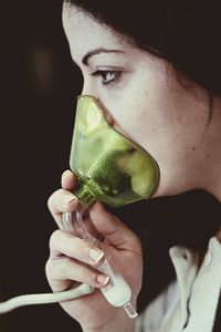 Close-up of woman wearing gas mask